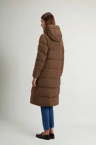 Madison Long Coat Dark Earth Coat by Woolrich shown from the back, featuring a stylish hood and puffy design.