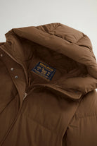 Madison Long Coat Dark Earth Coat featuring Woolrich branding and premium down filling for warmth.