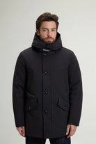 Stretch Parka Black Coat displayed on a model with stand-up collar and adjustable hood.