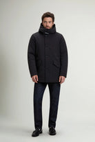 Stretch Parka Black Coat worn by a man, showcasing its premium design, stand-up collar, and adjustable hood.