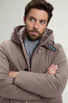 Man wearing the stretch parka falcon coat by Woolrich, showcasing its stylish design and warm features.