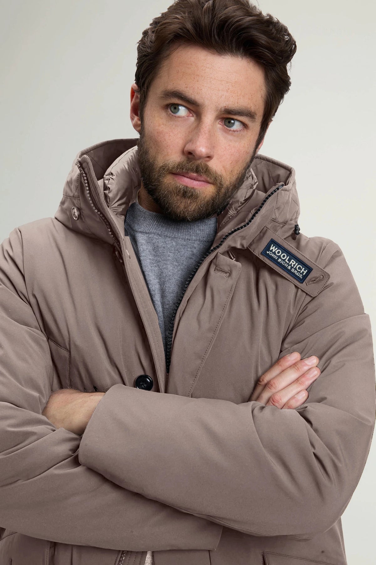 Man wearing the stretch parka falcon coat by Woolrich, showcasing its stylish design and warm features.