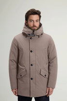 Man wearing a Stretch Parka Falcon Coat by Woolrich, showcasing its windproof and water-repellent features.