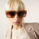 Person wearing Lana Sahara Sunglasses with gradient brown lenses and eco-made frame.