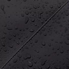 Close-up of waterproof fabric with droplets, showcasing Kumo Medium Lotus Infinity Black Backpack's durability.